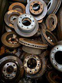 A pile of used and rusty brake discs stacked together.