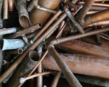 A pile of rusty, old copper pipes.
