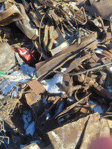 A cluttered pile of scrap metal and debris outdoors.