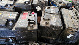 Several used and dirty car batteries arranged closely together.